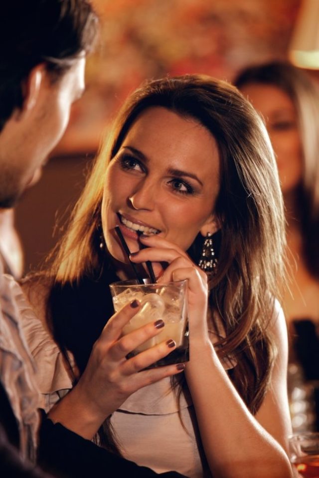 Flirtujúca žena pije slamkou