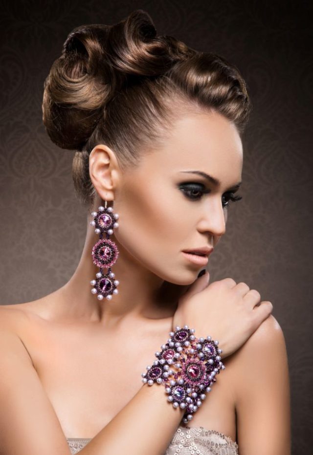 Žena s výraznými šperkami na ruke a uchu